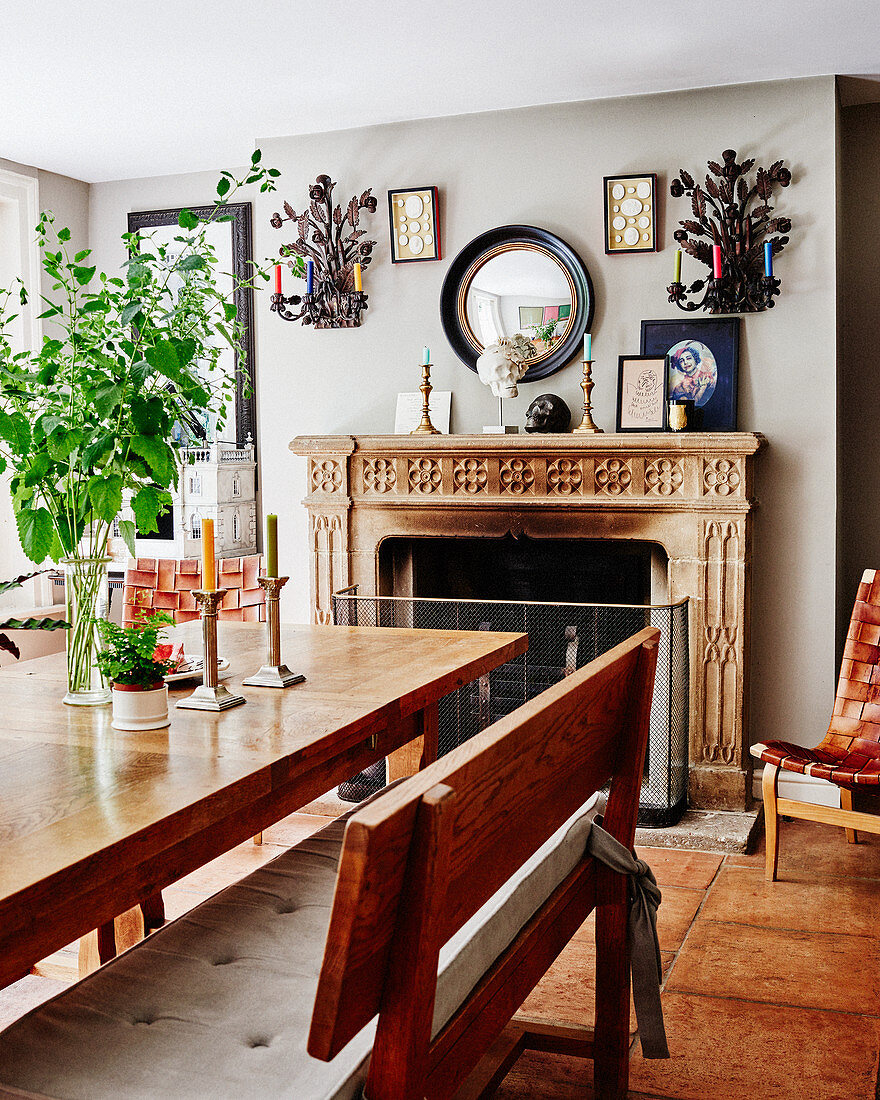 Wooden table and bench in front of open fireplace in dining room