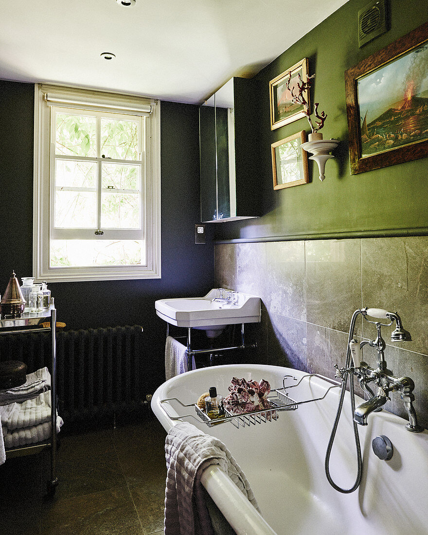 Vintage-style furnishings in dark bathroom with sash window