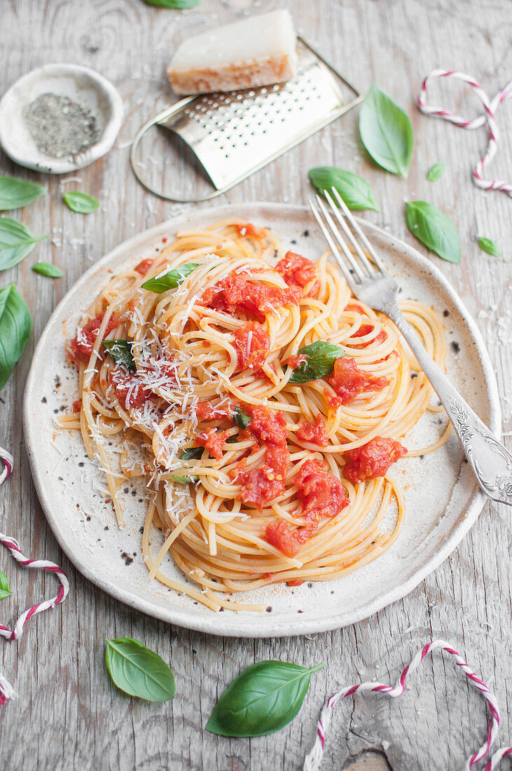 Spaghetti with tomato sauce, fresh basil and grated parmesan cheese