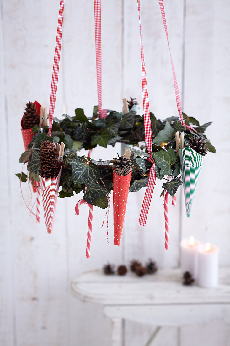 Suspended ivy wreath festively decorated with paper cones and candy canes