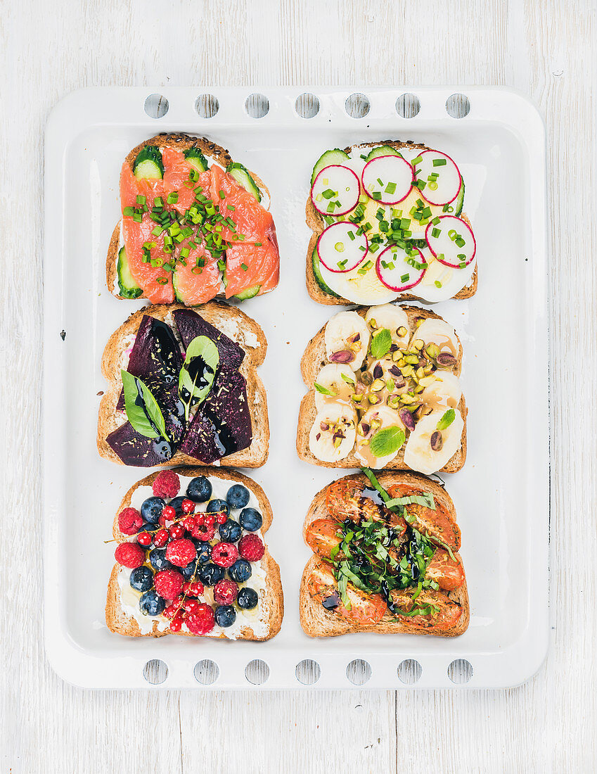 Sweet and savory breakfast toasts with fruit, vegetables, eggs and smoked salmon