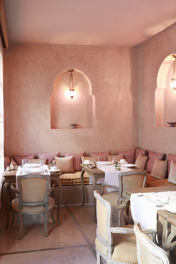 Oriental restaurant in shades of soft pink with lanterns in niches