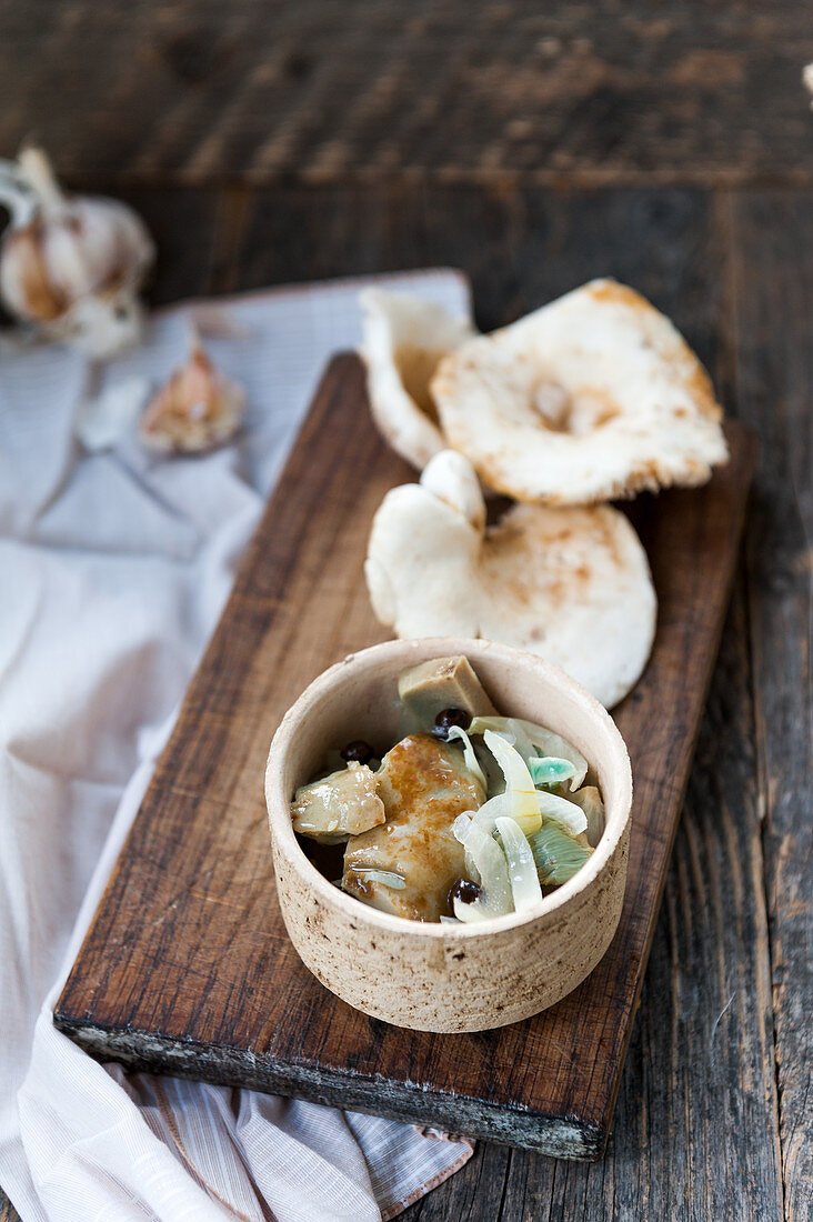 Pickled Lactarius piperatus mushrooms with onion, pepper and garlic