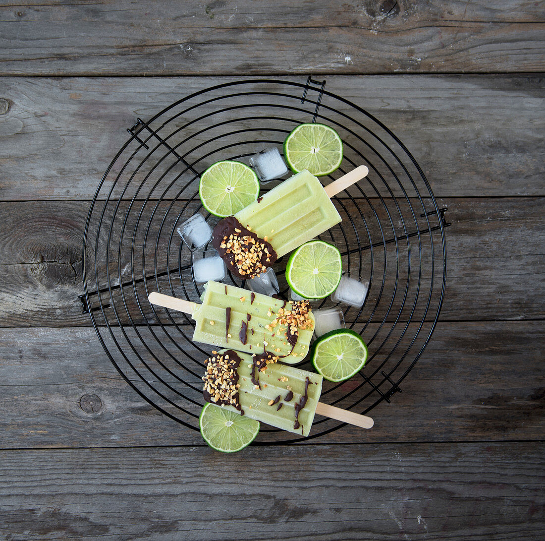 Avocado and lime popsicles with chocolate icing and hazelnuts
