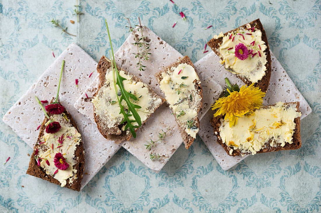 Dandelion and daisy butter, thyme butter, and dandelion butter on slices of bread