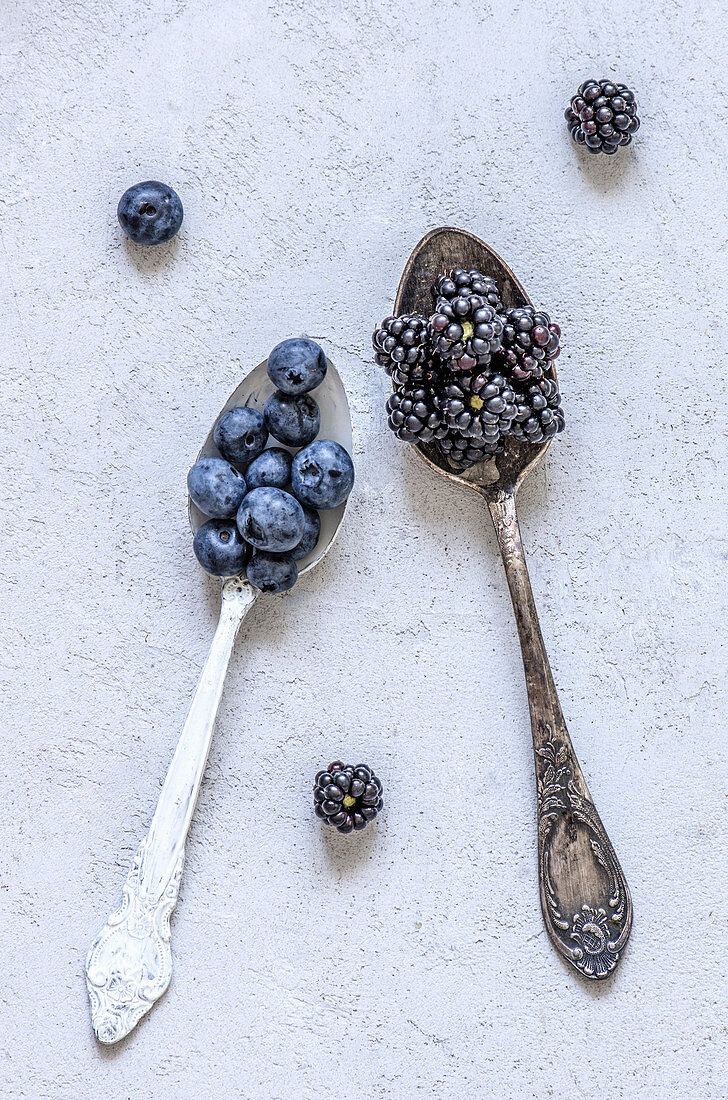 Blaubeeren und Brombeeren auf Vintage-Löffeln