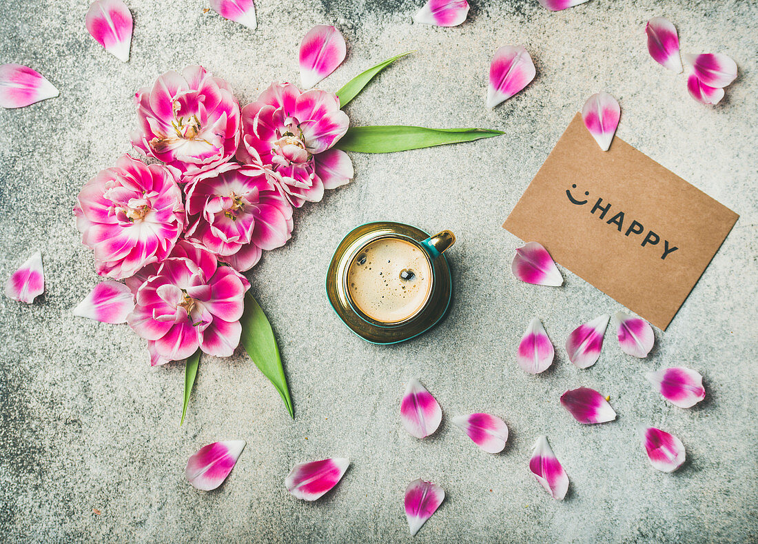 Tasse Kaffee, umgeben mit rosa Tulpen und Smiley auf Papier