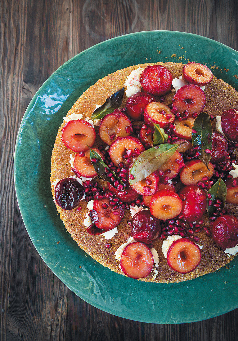 Polenta cake with fresh plums and pomegranate seeds
