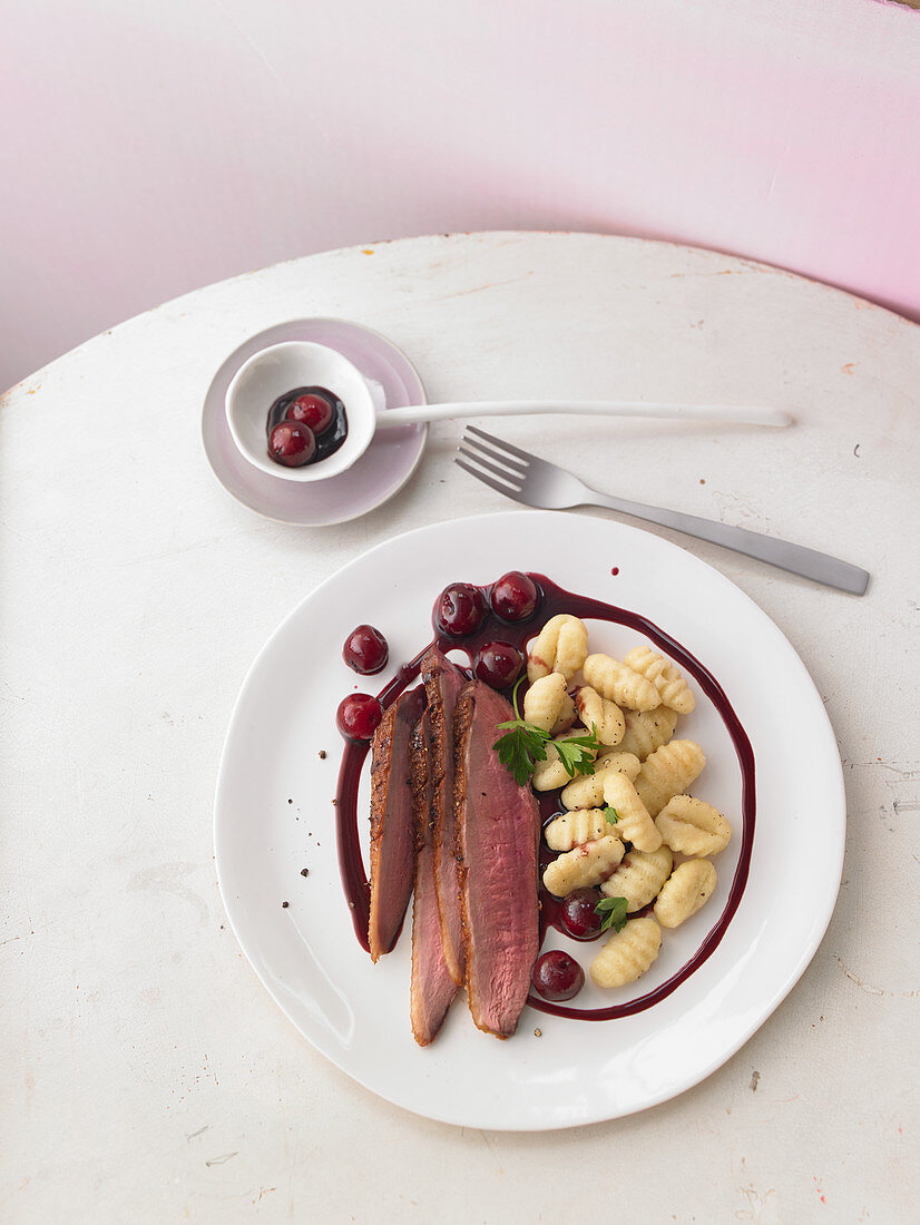 Crispy duck breast in a spicy balsamic reduction with cherries and gnocchi