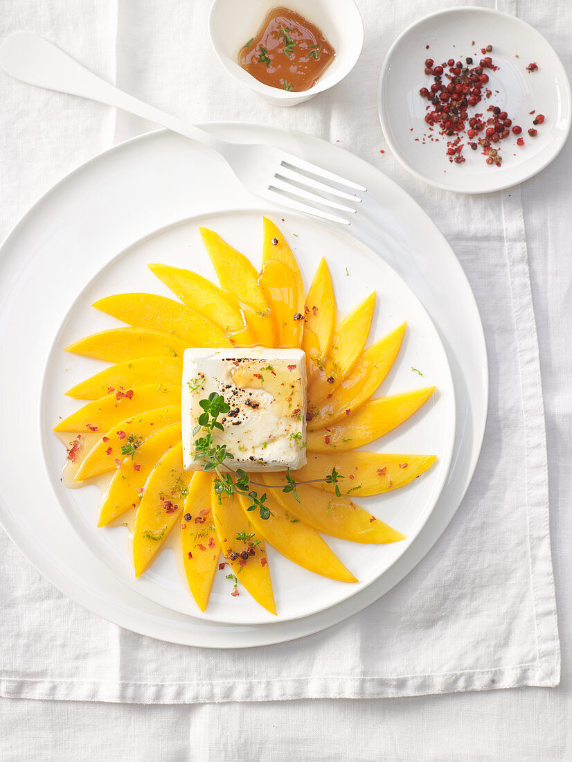 Grilled mango carpaccio with pink pepper and goat's cheese