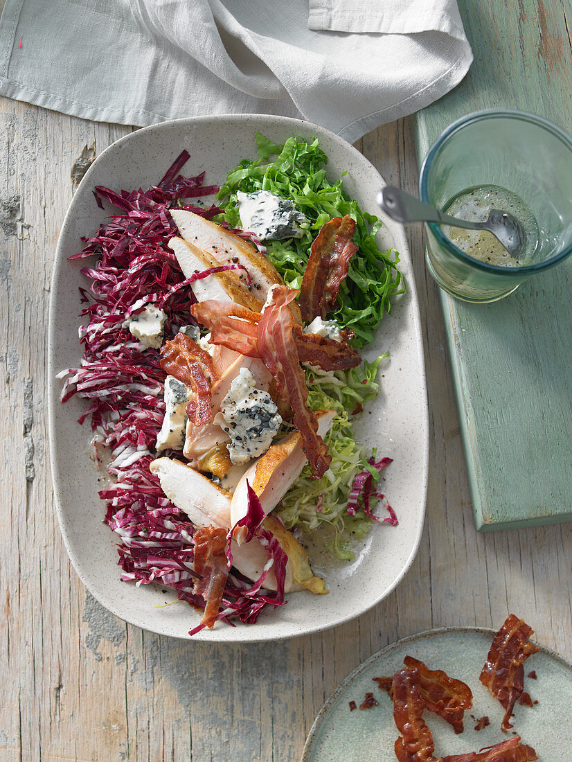 Cobb Salad (Radicchio, Endivie) mit gebratener Maispoularde, Blauschimmelkäse und Bacon in Ahornsirupdressing