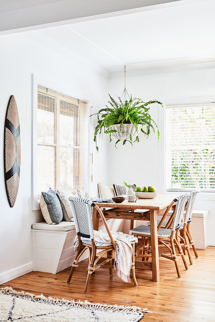 Dining table with corner bench and fern in hanging basket