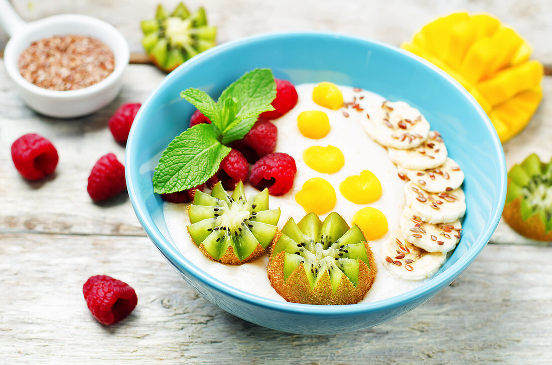 Frühstücks-Porridge mit Kiwi, Mango, Himbeeren, Banane und Leinsamen