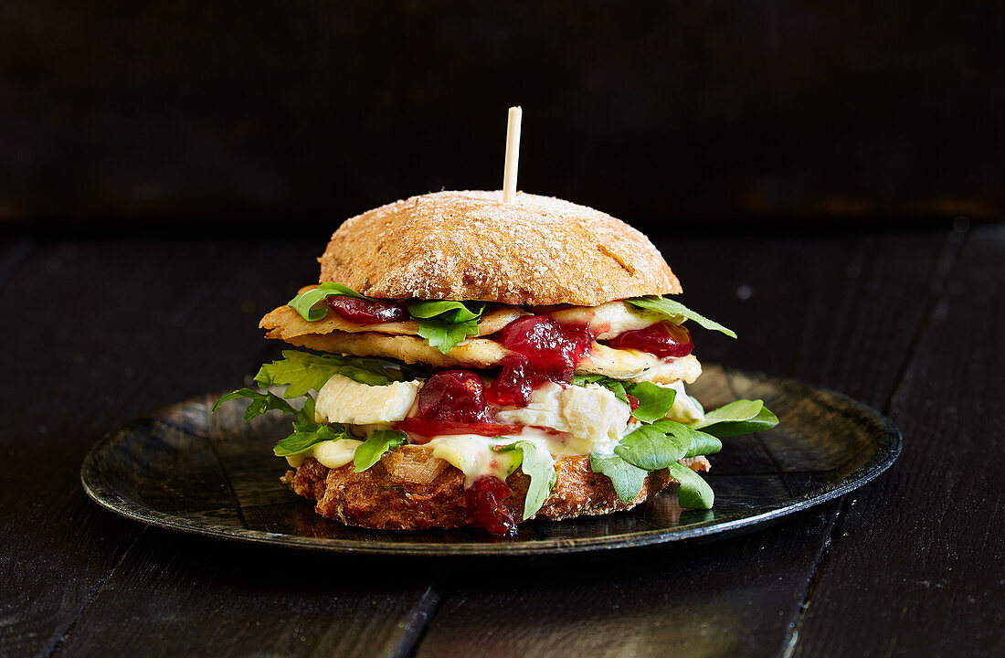 A chicken burger with camembert and cranberry sauce