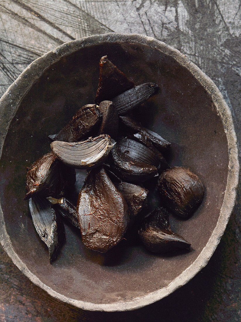 Black garlic in a wooden bowl