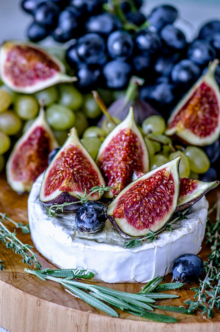 Cheese Camembert with figs, honey, grapes and fragrant herbs