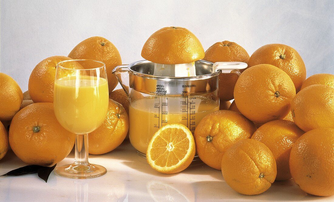 Viele Orangen, Orangensaft im Glas & im Meßbecher mit Presse