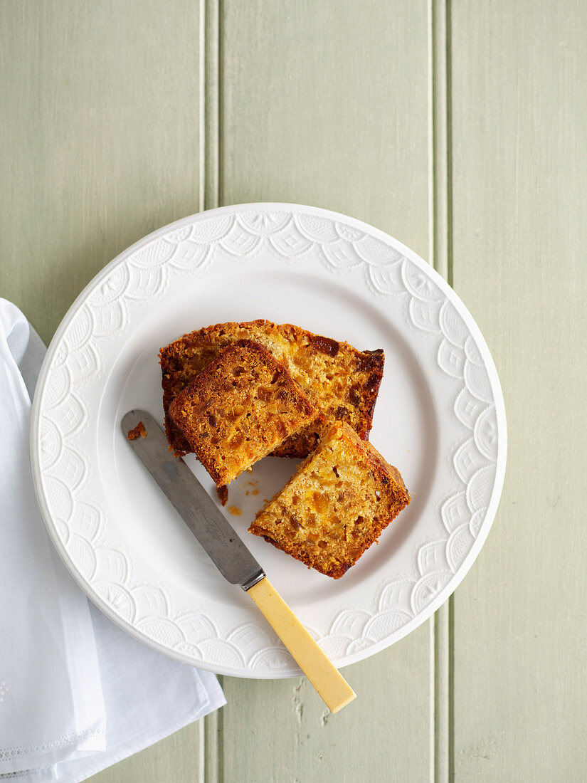 Früchtekuchen auf Teller mit Messer