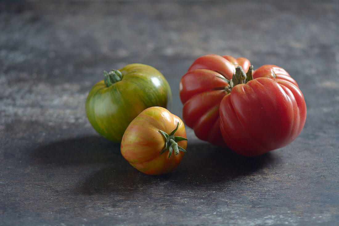 Zebra tomatoes and an ox heart tomato on a sheet metal