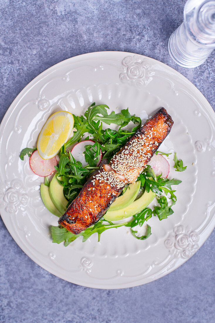 Roasted salmon coated with sesame seeds paired with lemon, arugula, radishes and avocado