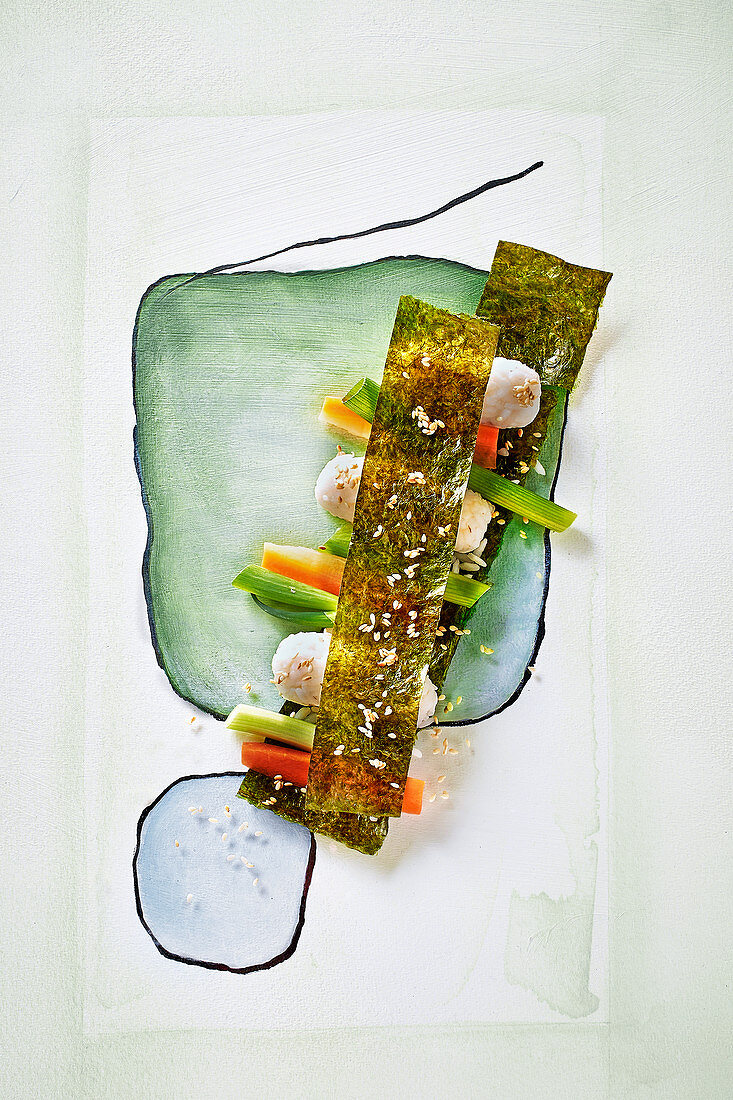 Sushi with vegetables and nori leaves on a painted surface