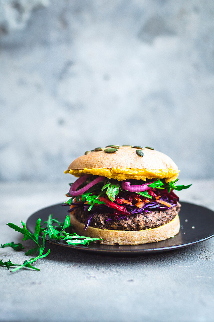 Black bean burgers with colourful toppings and hummus