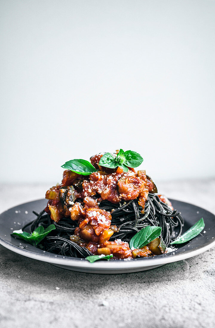 Spaghetti aus schwarzen Bohne mit Tomatensauce, Basilikum und veganem Käseersatz