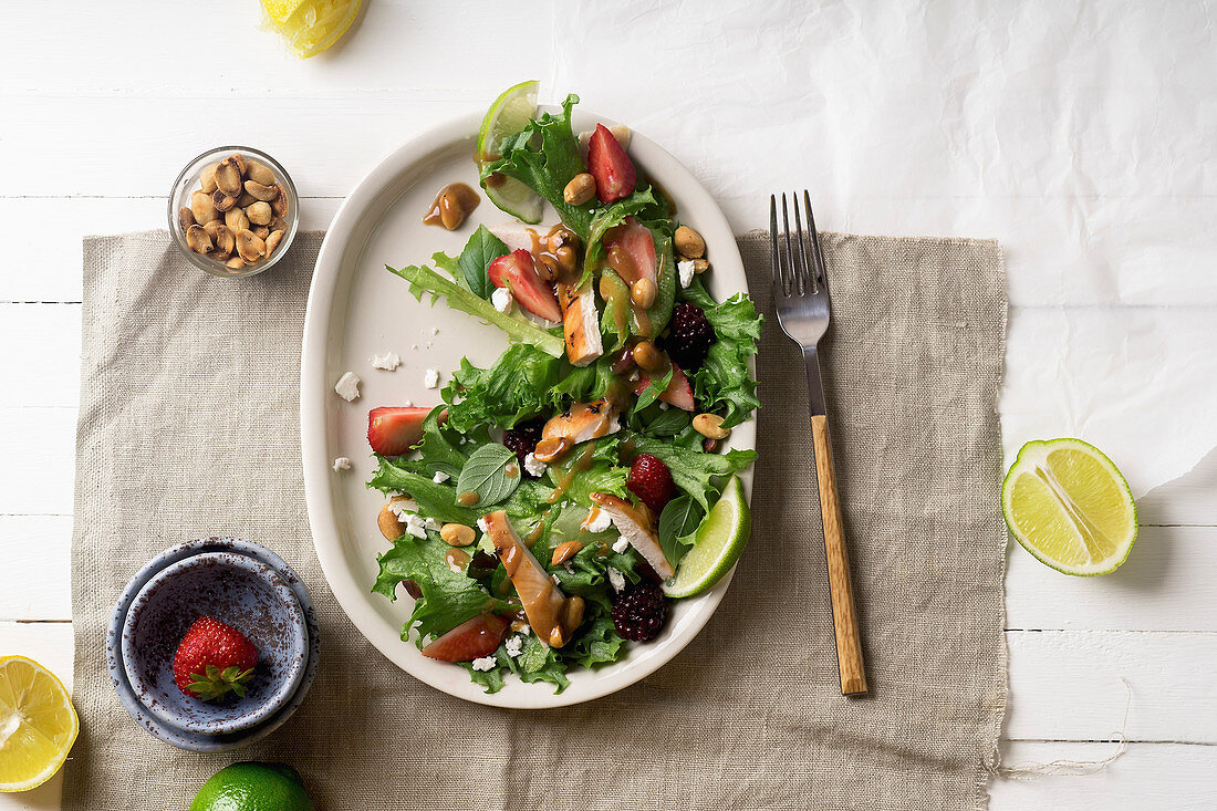 Fresh summer salad with berries, roasted chicken and sweet peanut dressing