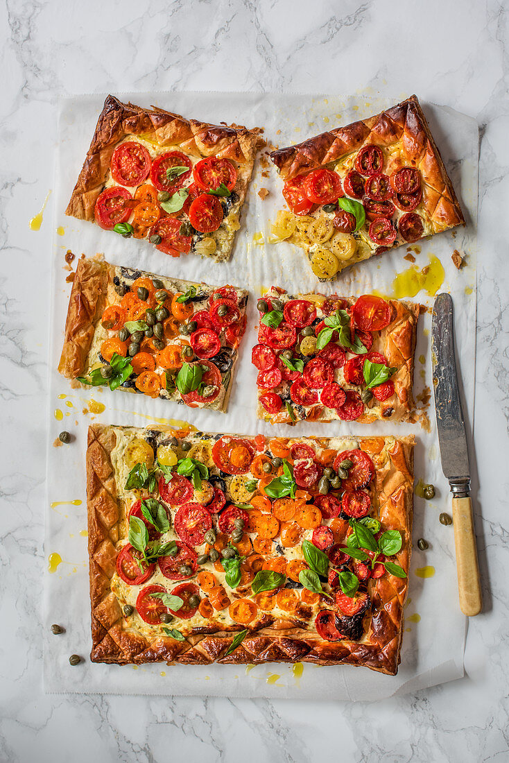 Puff pastry tomato tart with creme cheese, olives, capers and basil