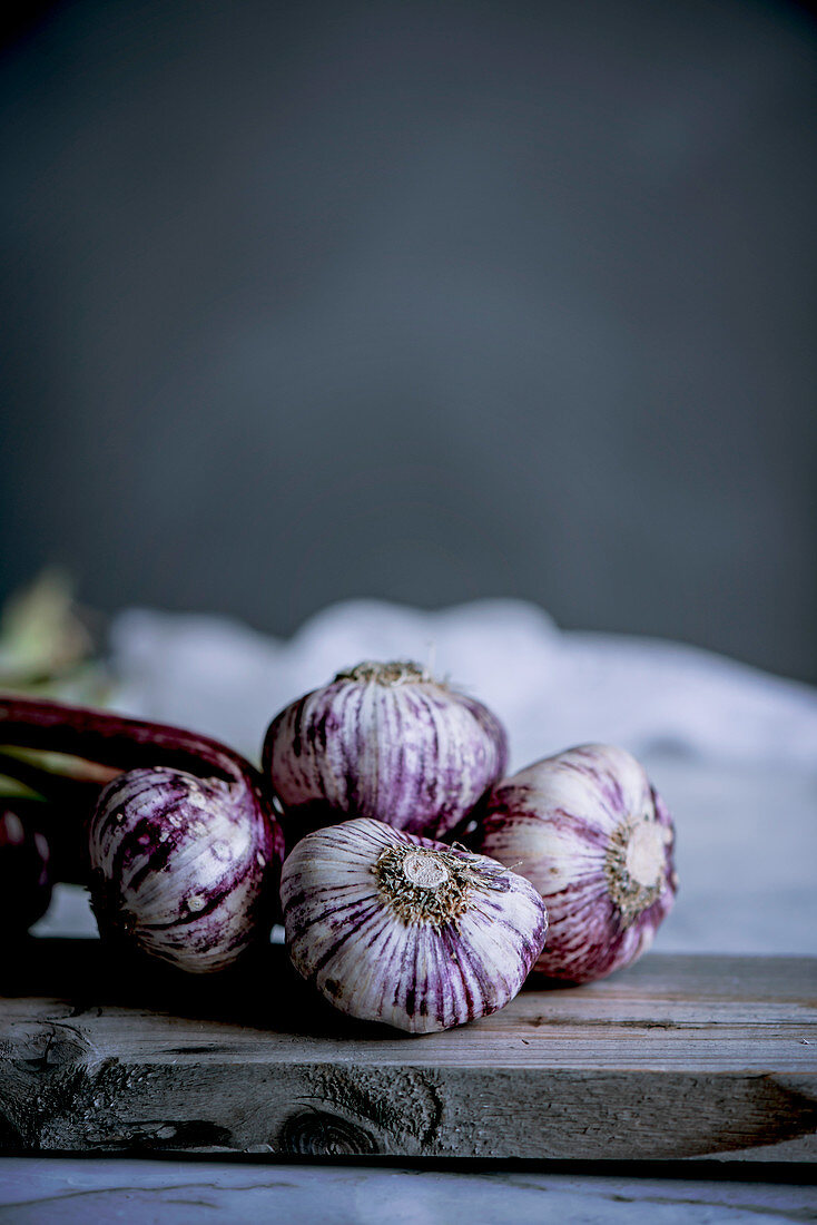Purple and white garlic bulbs in a rustic kitchen