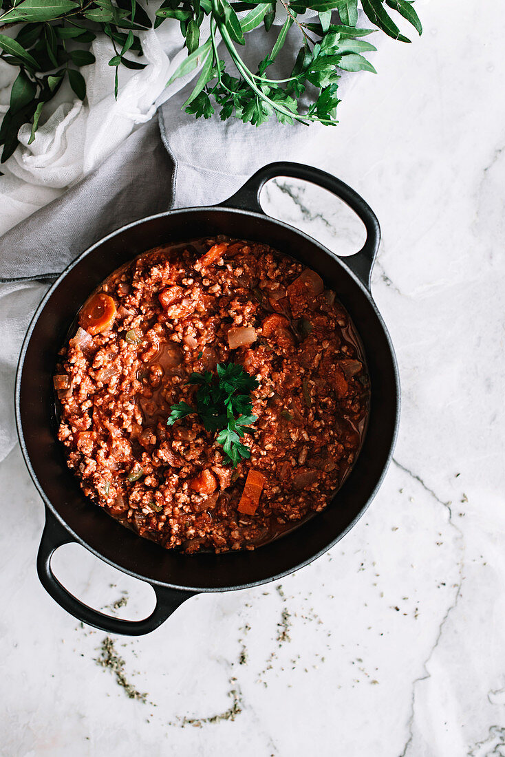 Bolognesesauce im Topf auf Marmoruntergrund (Aufsicht)