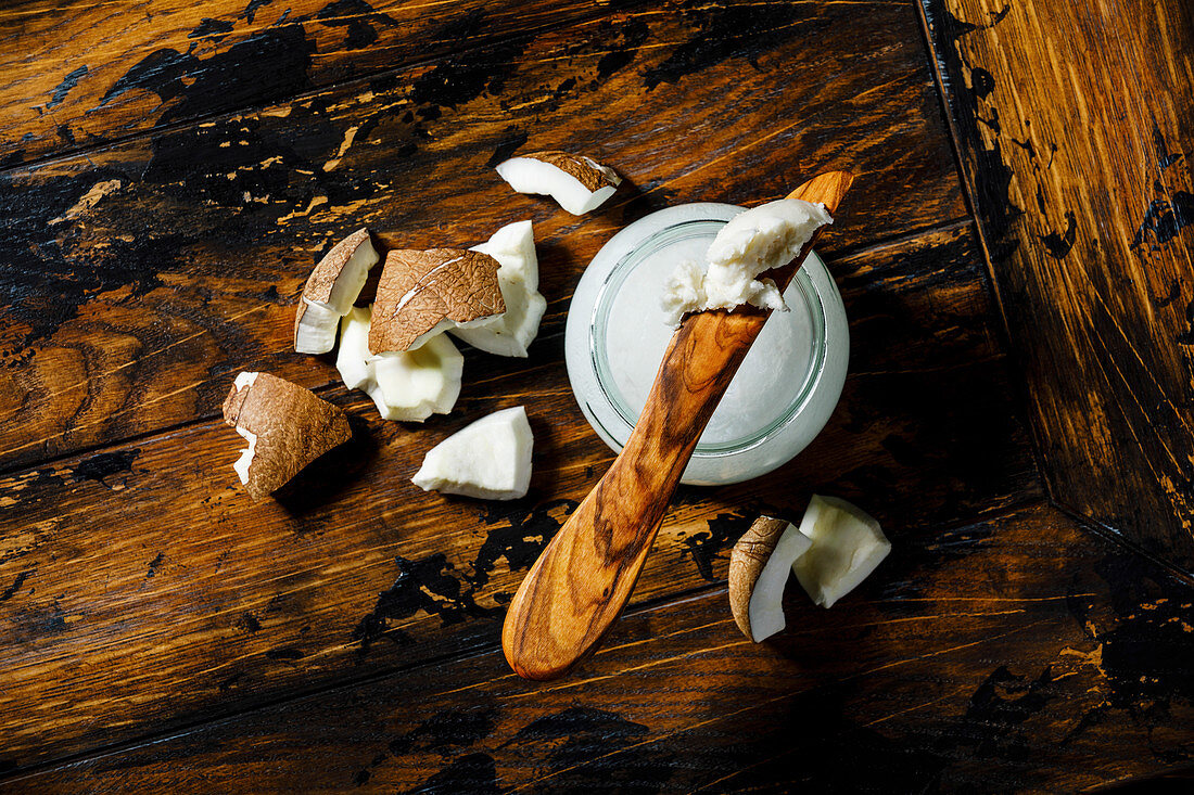 Organic healthy Coconut butter and fresh coconut pieces on wooden background