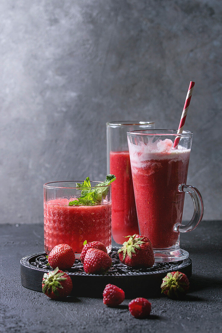 Drei verschiedene rote Fruchtsmoothies mit Erdbeere, Wassermelone und Granatapfel