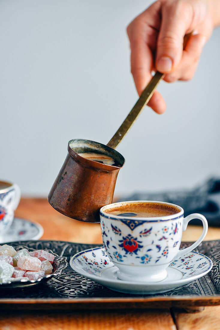Türkischer Kaffee wird aus Cezve in Tasse gegossen