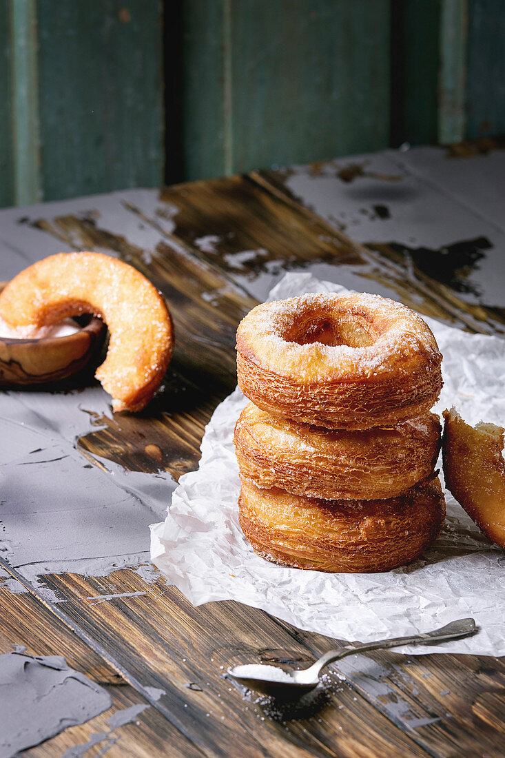 Homemade puff pastry deep fried donuts or cronuts in stack with sugar