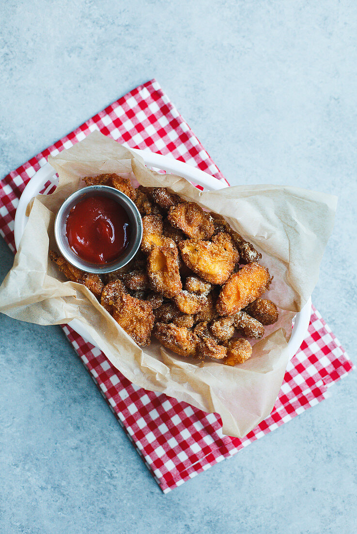 Fried cheese curds in basket with ketchup