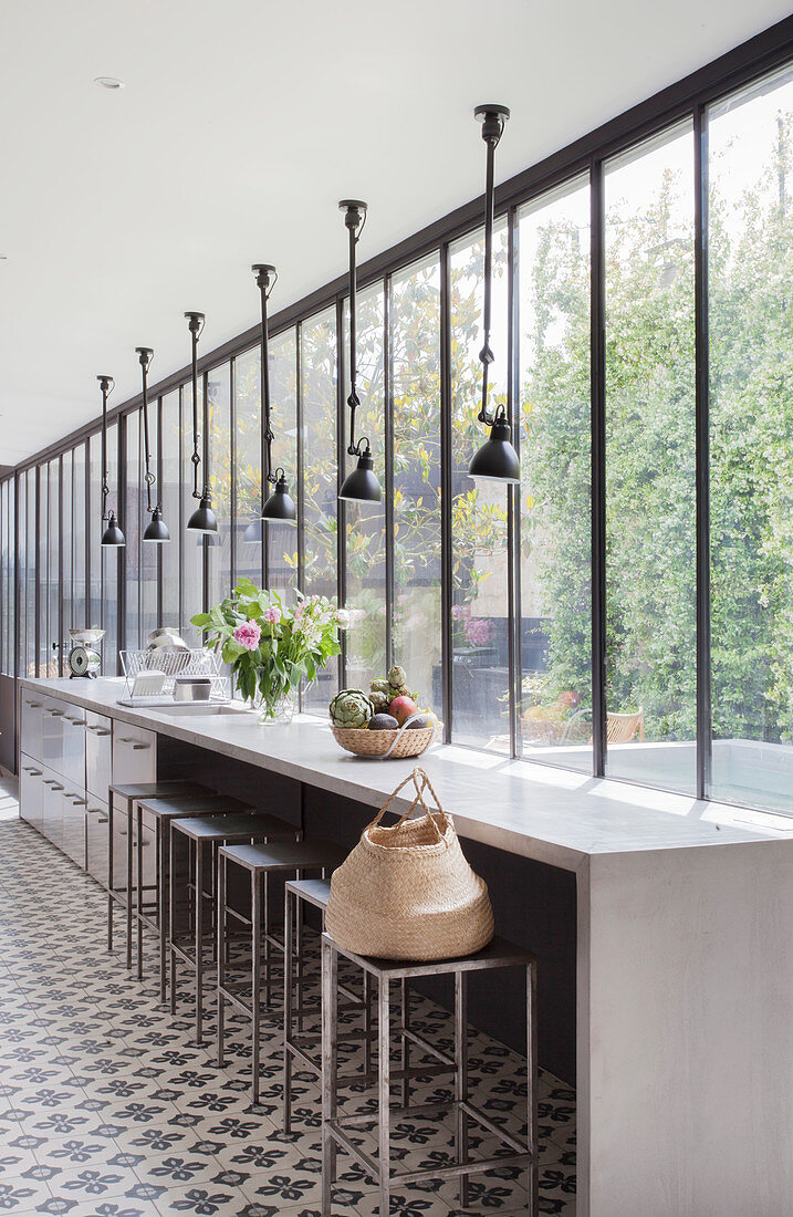 Lange Küche mit Betontheke, Zementfliesen und Verglasung
