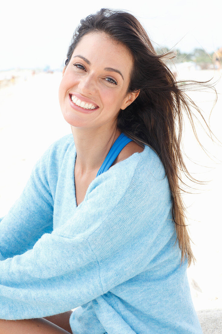 A brunette woman wearing an oversized blue jumper