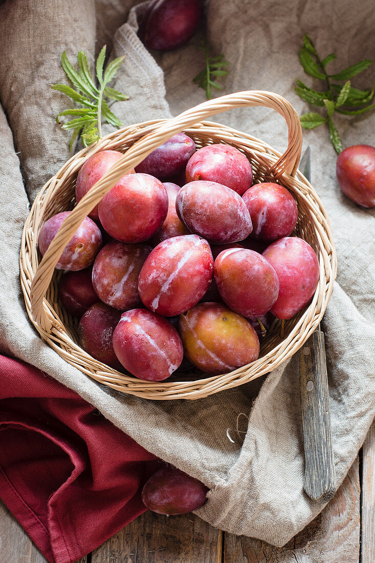 Rote Pflaumen im Weidenkorb