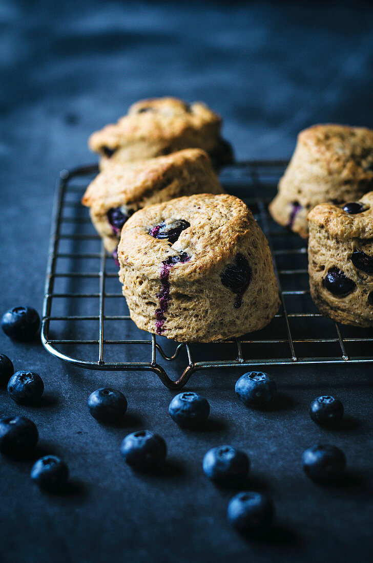 Vegan blueberry scones on baking rack with dark background