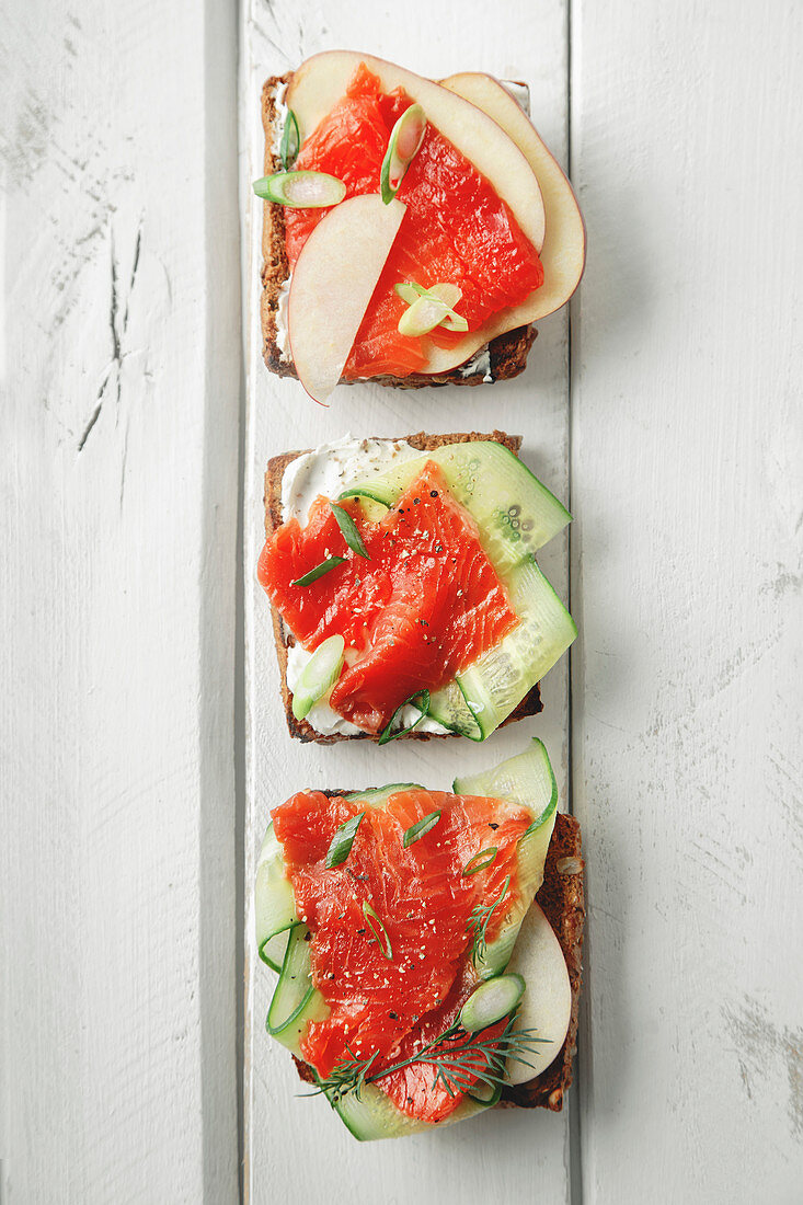 Danish traditional snack smorrebrod with salmon, cucumbers and cream cheese