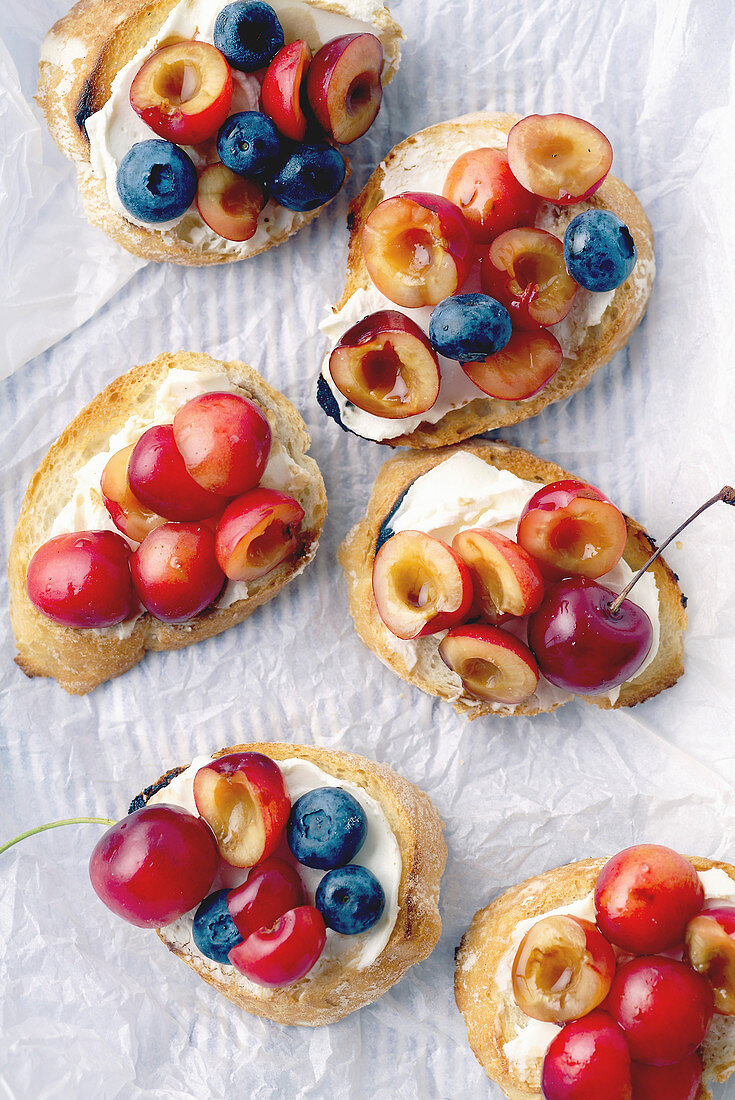 Bruschetta with cherry, blueberry, honey sauce and cream cheese