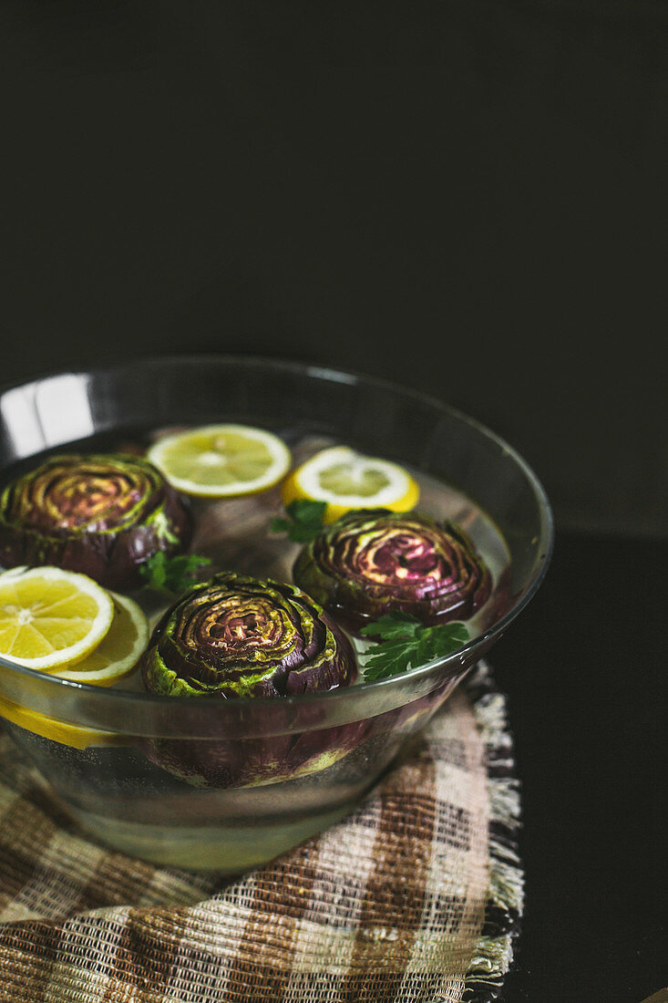 Artichokes in water with lemons for flavouring