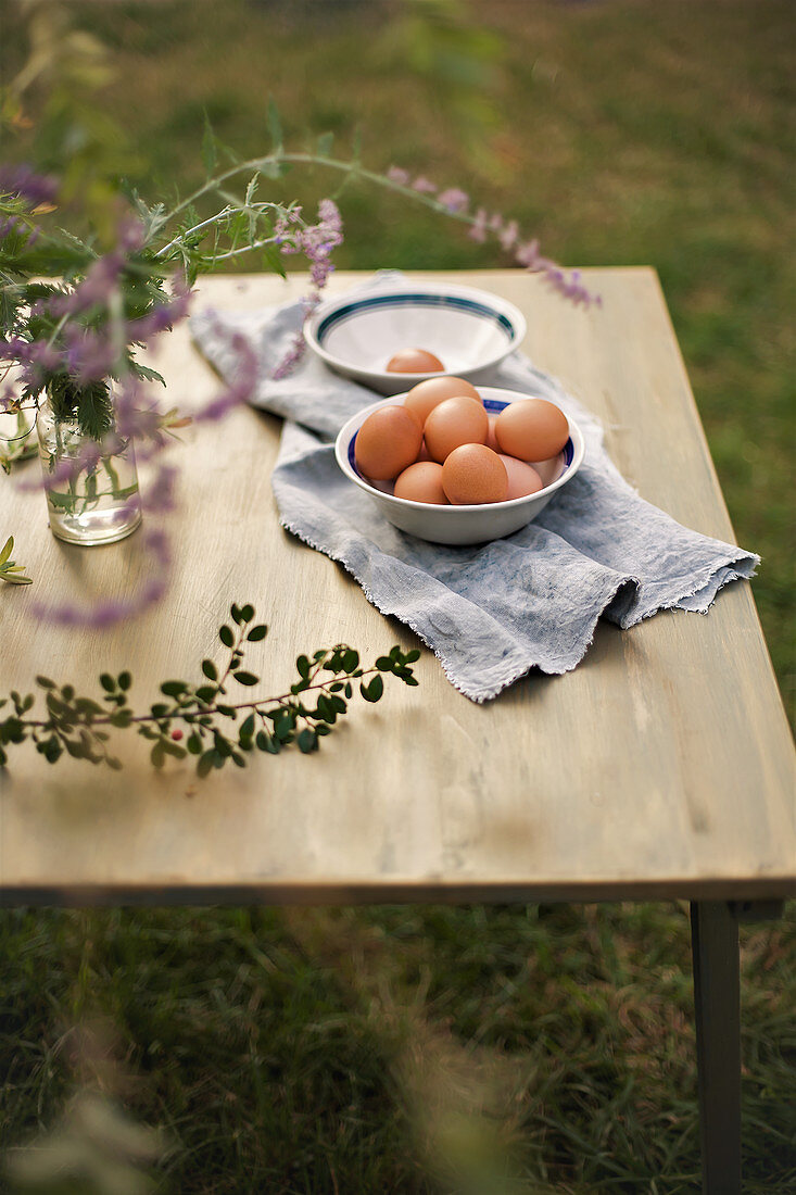 Bowl of eggs on cloth on table in garden