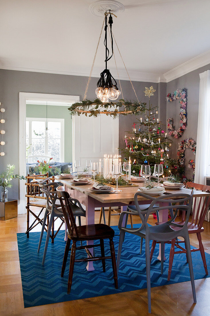 Festlich gedeckter Tisch und geschmückter Tannenbaum im Esszimmer