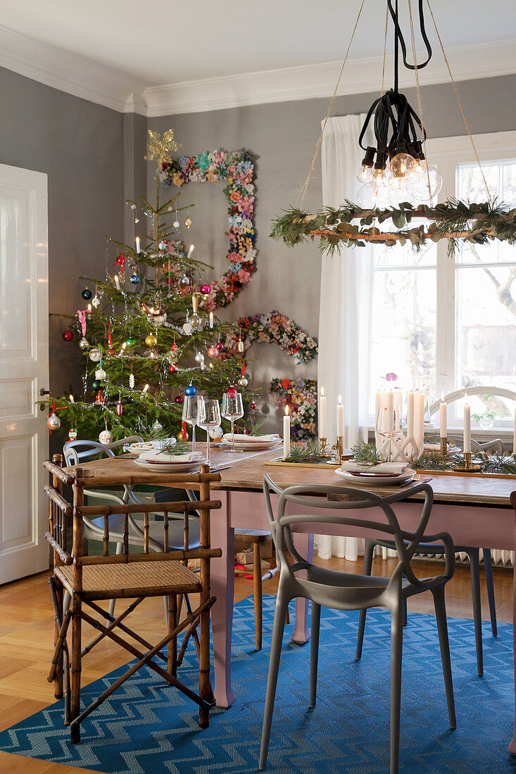 Festively set table and decorated Christmas tree in dining room