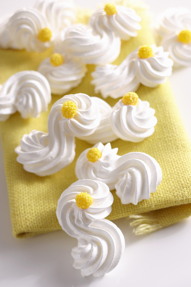 Delicate meringue shapes with yellow sugar decorations