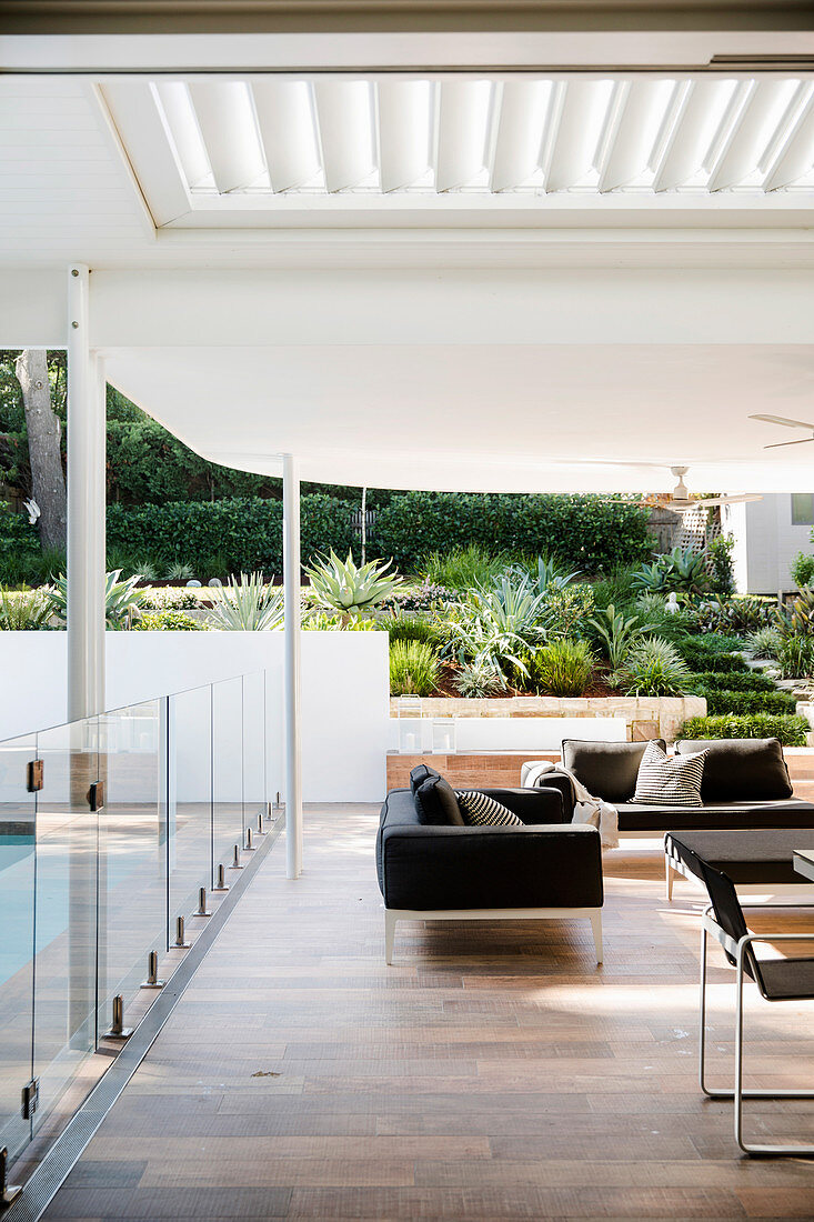 Elegante, überdachte Terrasse mit Glasbalustrade