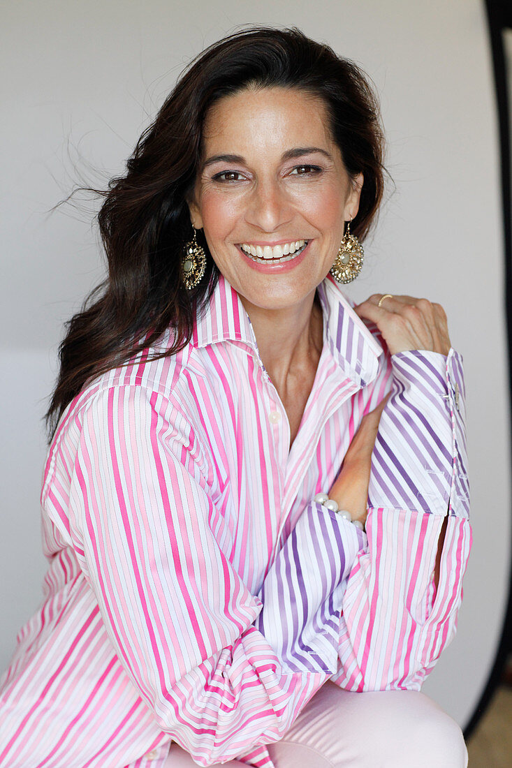A dark-haired woman wearing a striped shirt blouse