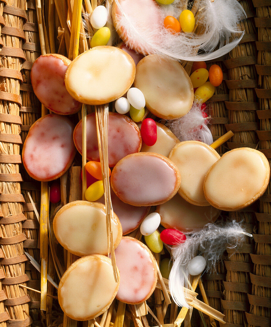 Glazed lemon and raspberry cookies in a woven basket with feathers for Easter